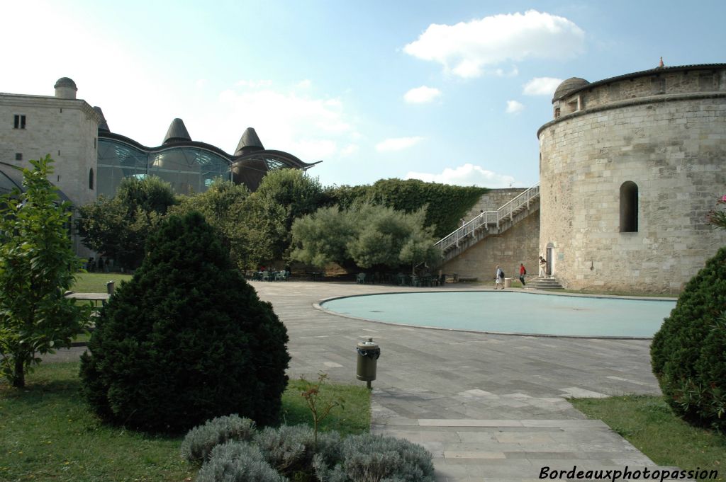 Une vaste cour-jardin accueillante limitée par le mur d'enceinte de l'ancien fort du Hâ. 
