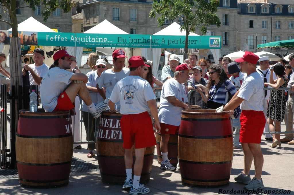 Il fait très chaud sur les quais de la Garonne. Les rouleurs de barriques de Lussac Saint-Émilion attendent à l'ombre que les échassiers landais achèvent leur prestation pour montrer à leur tour ce qu'ils savent faire.