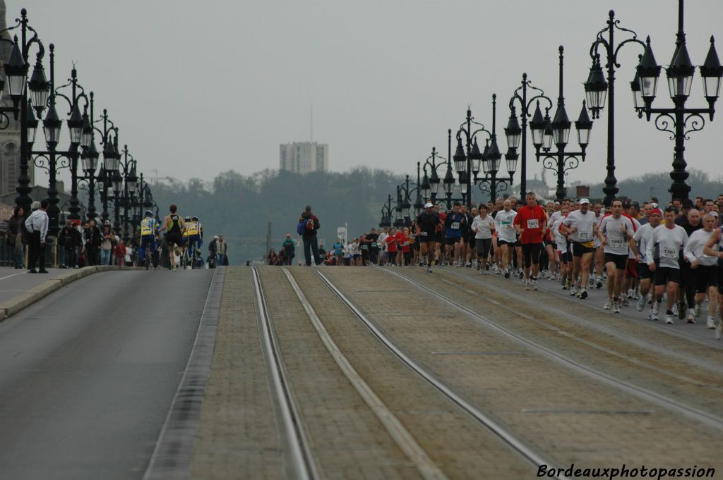 Si sur la partie droite du pont, la majorité des athlètes suit son train de semi-marathon, sur la partie gauche, les plus rapides des Foulées des deux rives (10km) foncent déjà vers l'arrivée.