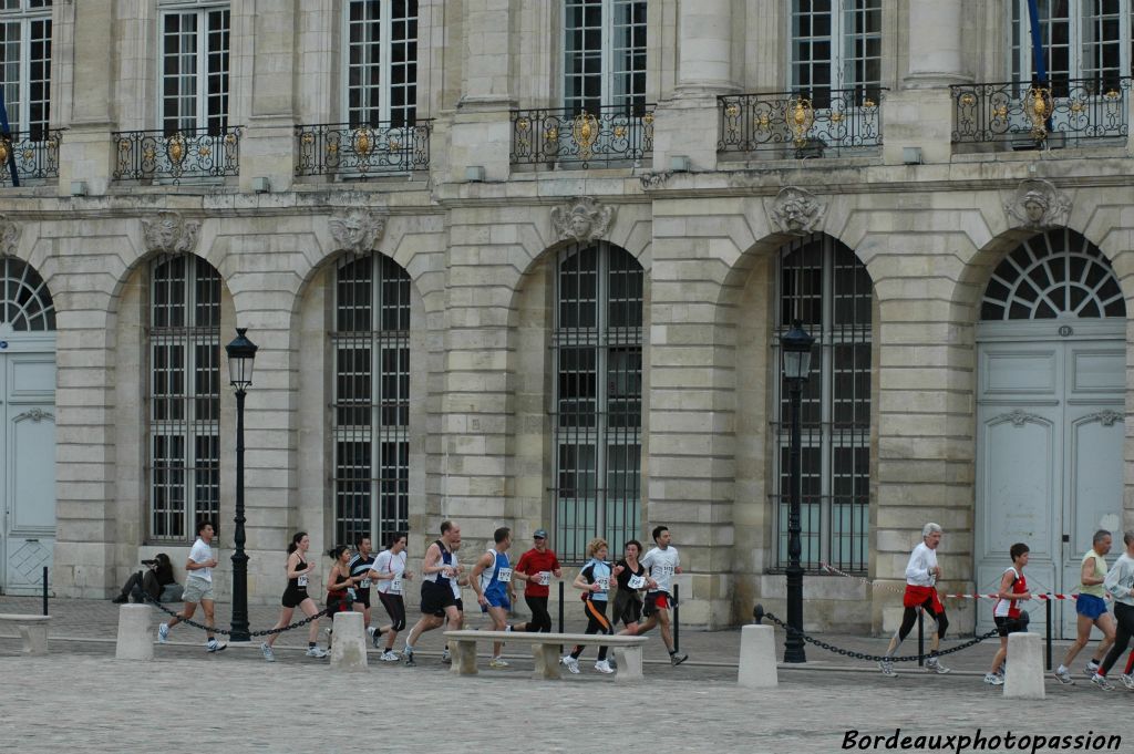 Au-dessus des fenêtres, les mascarons du XVIIIe siècle semblent apprécier le spectacle.