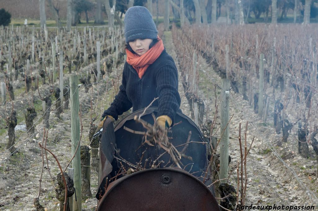 Elle dépose sur le feu des sarments qui vont brûler rapidement.