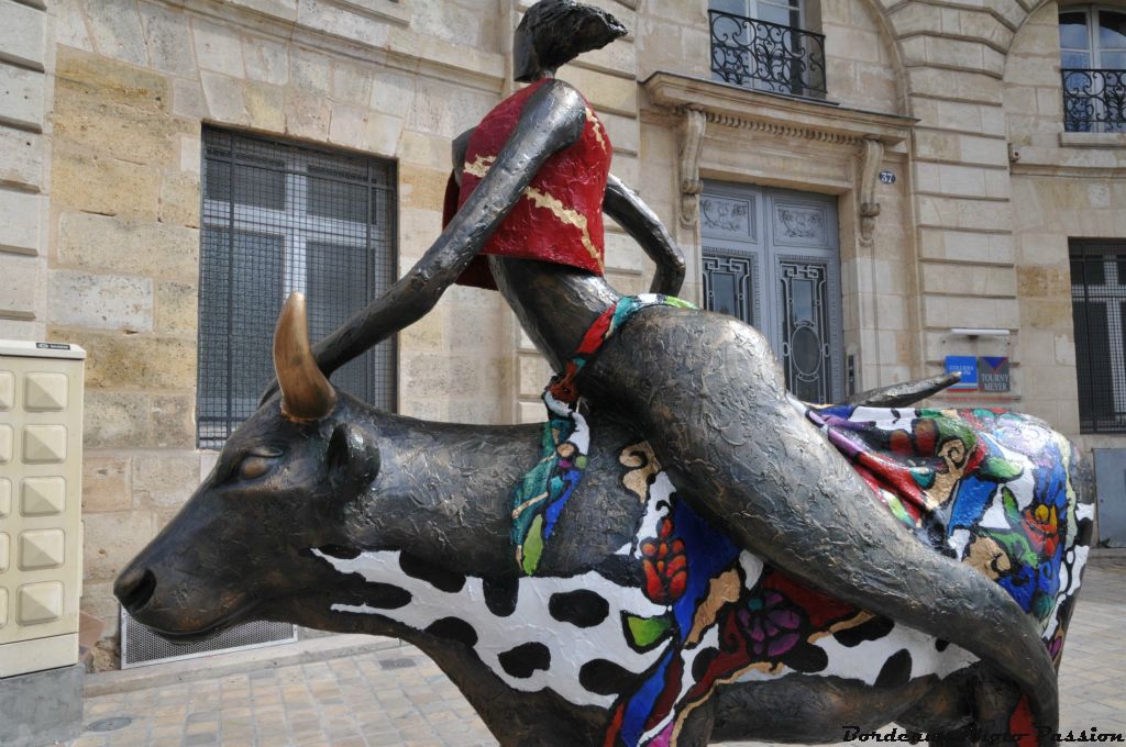 Une vache avec un personnage sur le dos qui a réussi à y rester.