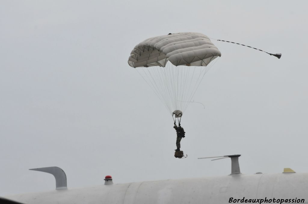 Le paquetage pend sous le parachutiste.