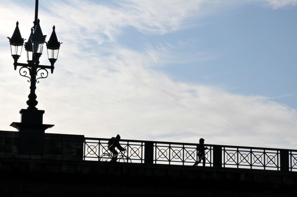 Silhouettes sur pont de pierre.