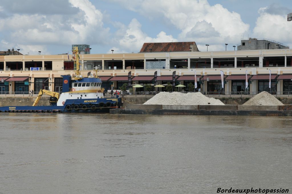 Au premier plan un bateau "pousseur" va bientôt guider la barge chargée de gravats vers le chantier de la décennie du nouveau pont sur la Garonne.