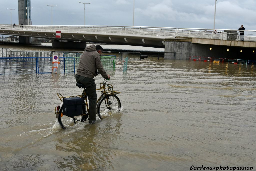 Ce n'est pas un peu d'eau qui va arrêter ce cycliste.