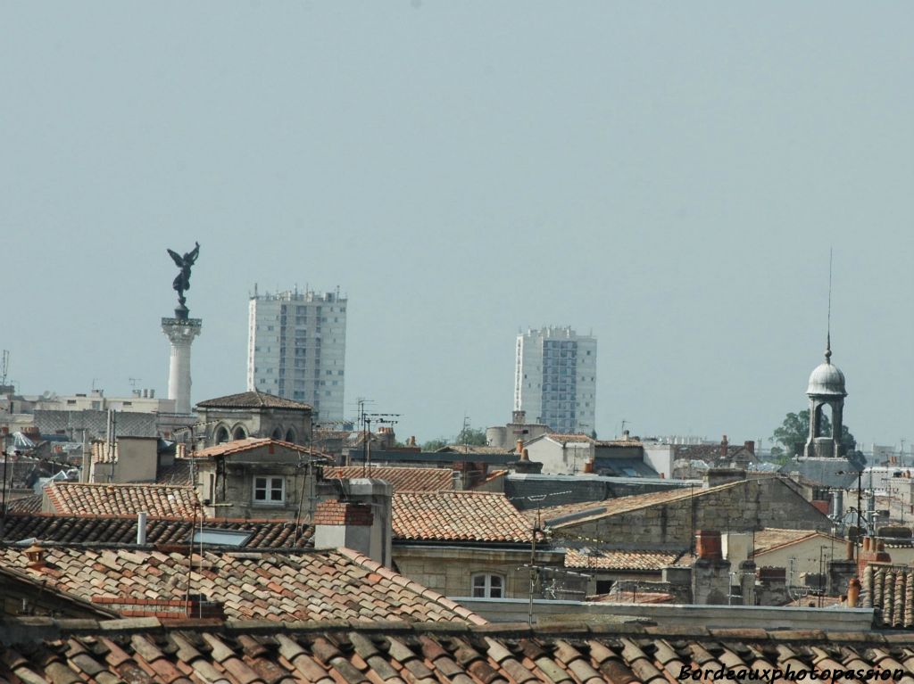 A gauche, le clocher de l'église Saint-Pierre à côté de la République ailée du monument aux Girondins.