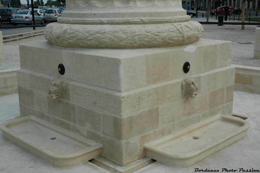 Une couronne de lauriers est sculptée à la base de la colonne.