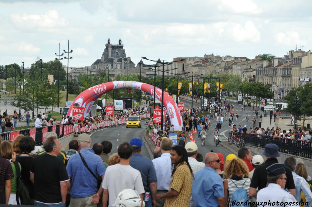 La flamme rouge franchie, ils passeront sous le pont de pierre. Les spectateurs le savent et sont judicieusement installés.