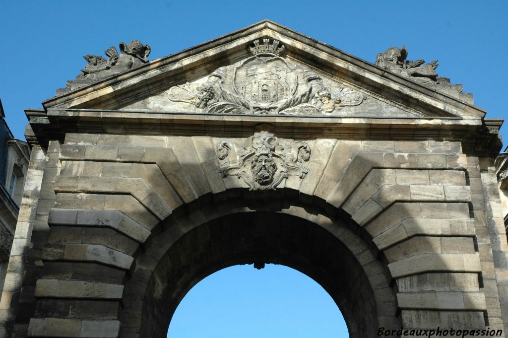 Côté ville, le fronton triangulaire souligne les armoiries de la ville au-dessus d'une la tête de Neptune regardant la Garonne.