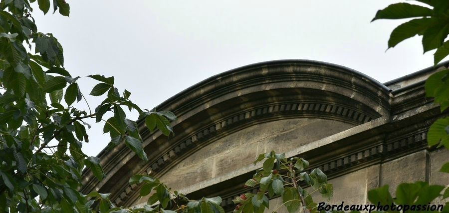 Entablement saillant avec un fronton en demi-lune décoré de denticules.