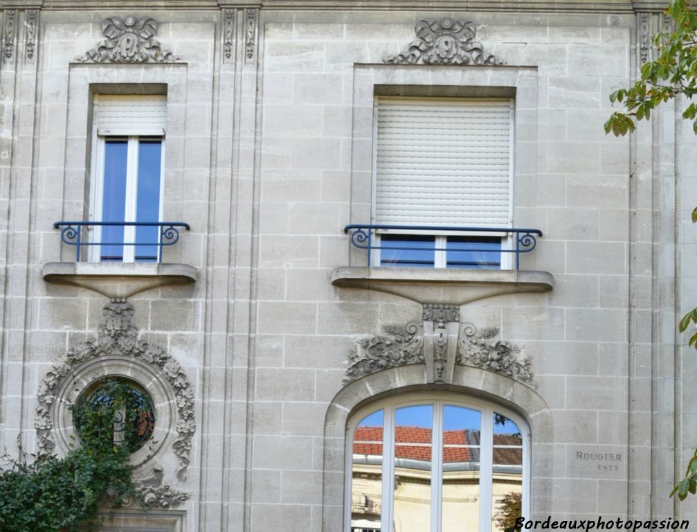 Présence d’une fenêtre en anse de panier plus XXe siècle. Mais il reste les pilastres évoqués par le rainurage et surtout le décor floral avec rubans, très présent autour de la porte d’entrée.