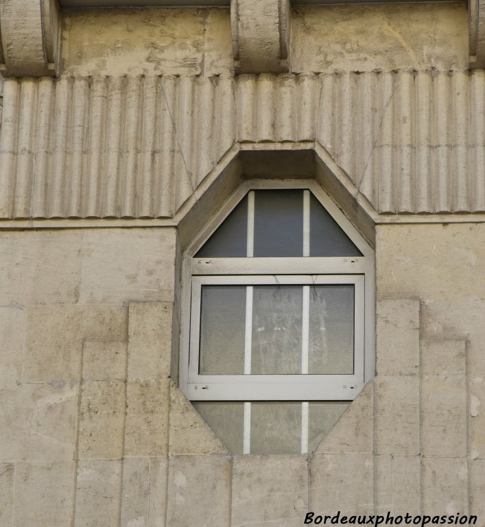 Décoration sculptée plus minimaliste au-dessus de la porte. Ce style semble tirer vers le  le cubisme.