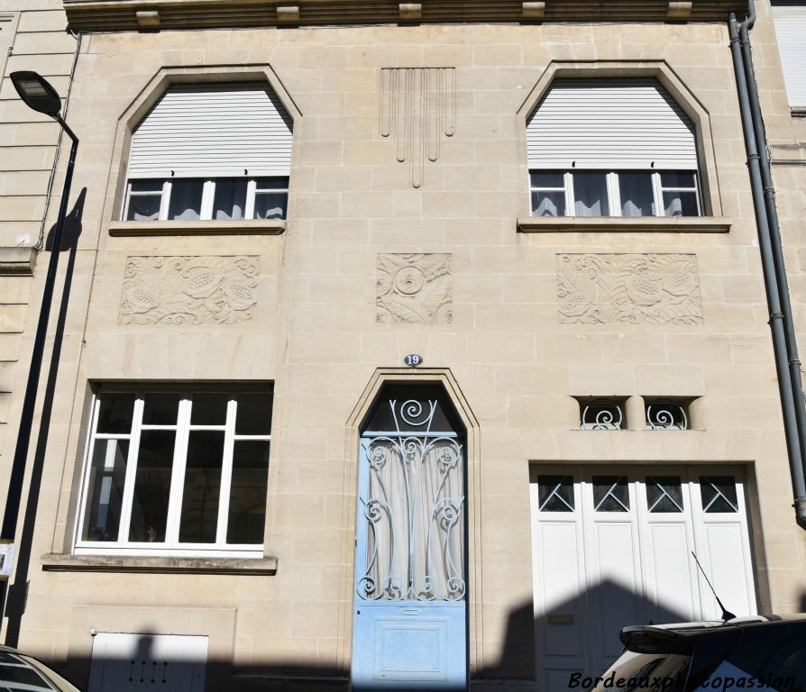 Par Géo Contant. Ouvertures à pans coupés pour les fenêtres du 1er et la porte d’entrée. Façade bien animée par les ouvertures.