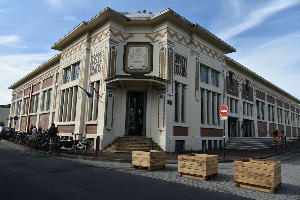 Située à l'angle de la rue Carnot et de la rue Francis de Pressensé à Bègles, la piscine municipale offre une façade richement décorée.