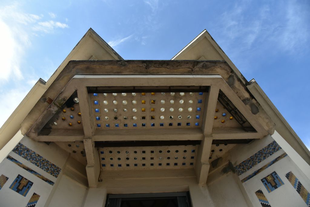 Située au centre géographique de la ville, la piscine a été imaginée et construite en béton armé par l'architecte-ingénieur Armand Blanchard. Auvent de l'entrée avec pavés de verre d'origine.