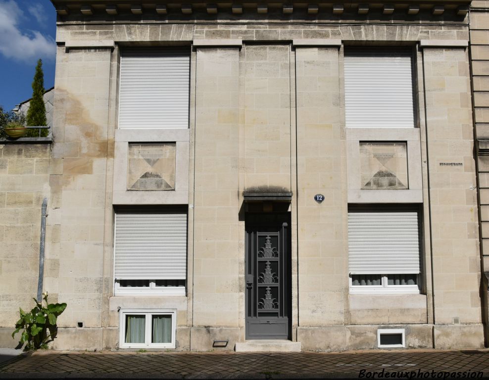 Décoration minimale pour cet immeuble avec trois travées mises en évidence par un rainurage.