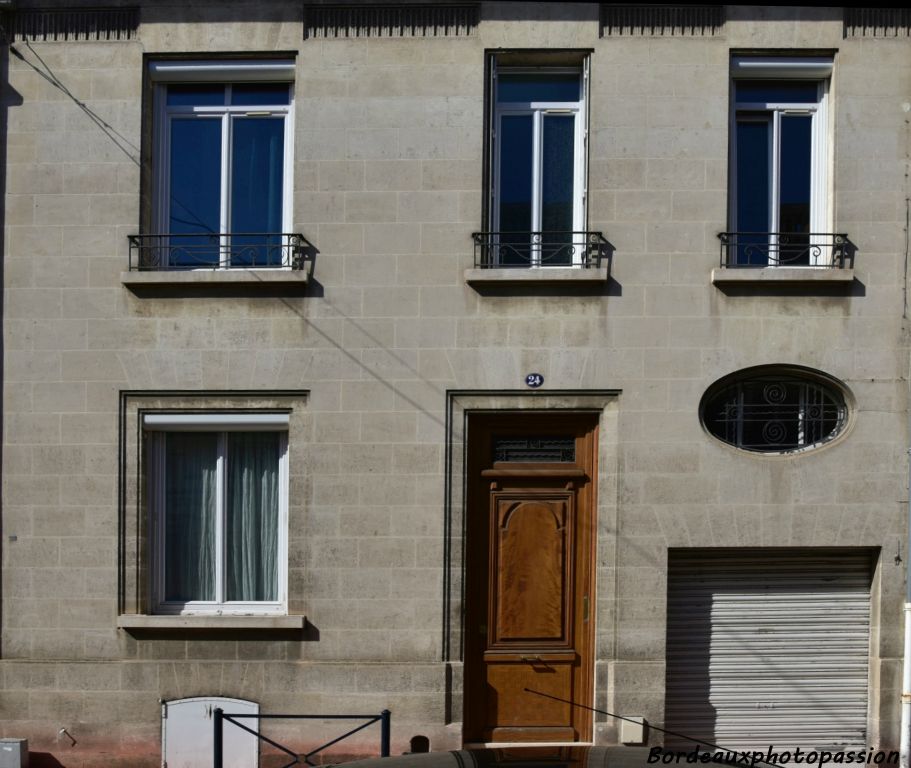 Maison avec peu de décoration. Les ouvertures du bas sont soulignées. La ferronnerie reprend la volute et la corbeille chères à l'Art Déco.