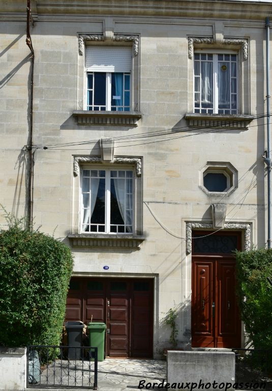 Les baies sont entourées de sculptures saillantes contrairement à sa voisine de gauche.  Seul l'œil de bœuf est à pans coupés.