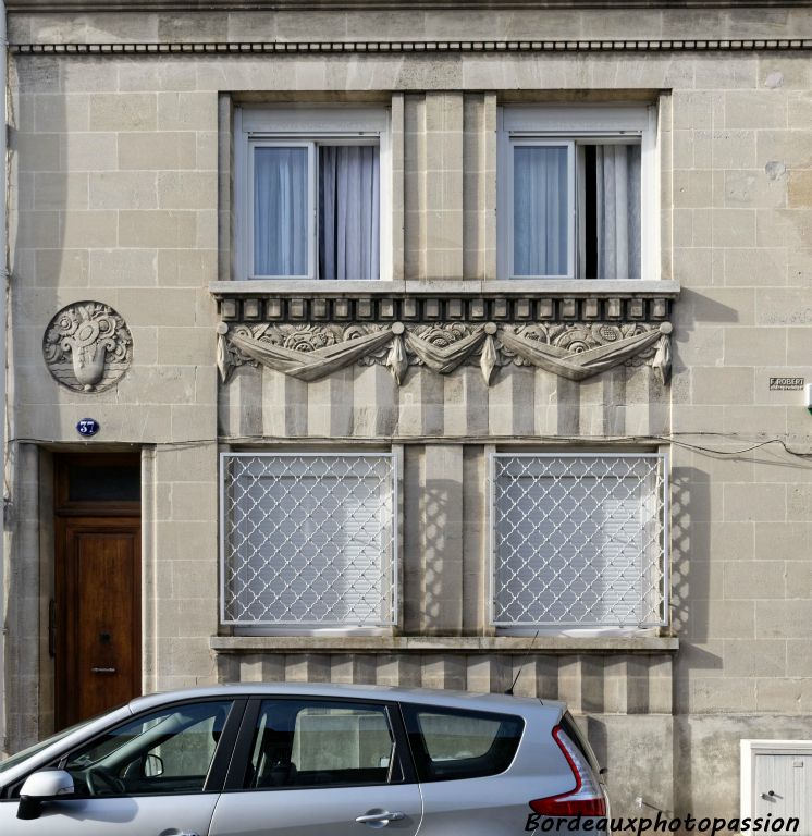 Façade originale avec des fenêtres groupées mises en valeur par une décoration variée.