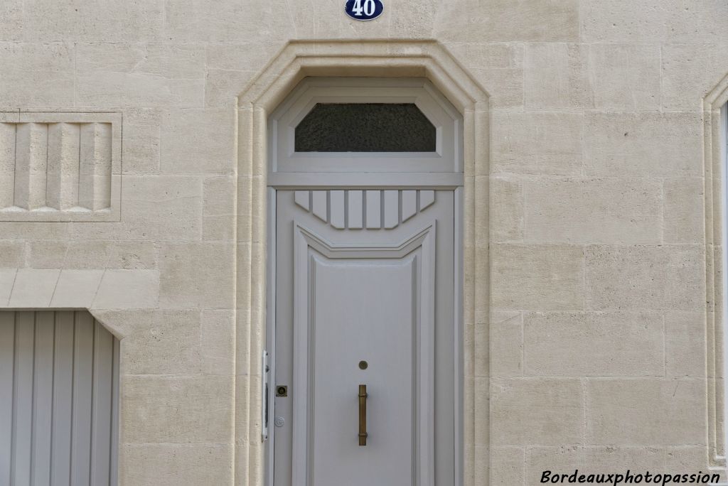 Porte en bois avec rappel du même motif que celui de la pierre.