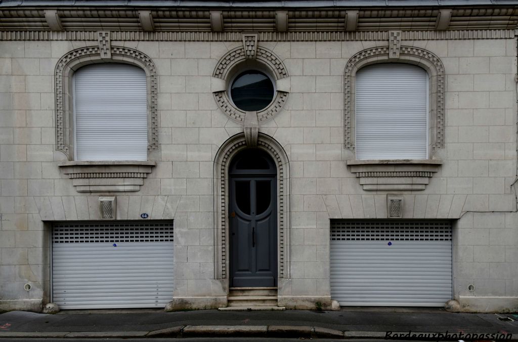 Cette maison se distingue par la couleur blanche de sa pierre, ses deux garages et la décoration très géométrique de son entablement et de ses ouvertures.