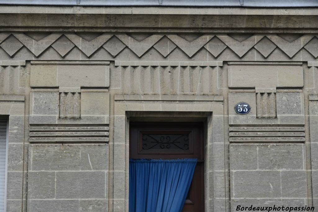 Un rainurage horizontal souligne les panneaux en éventail. La frise en ligne brisée contraste avec la verticalité du reste de la décoration.