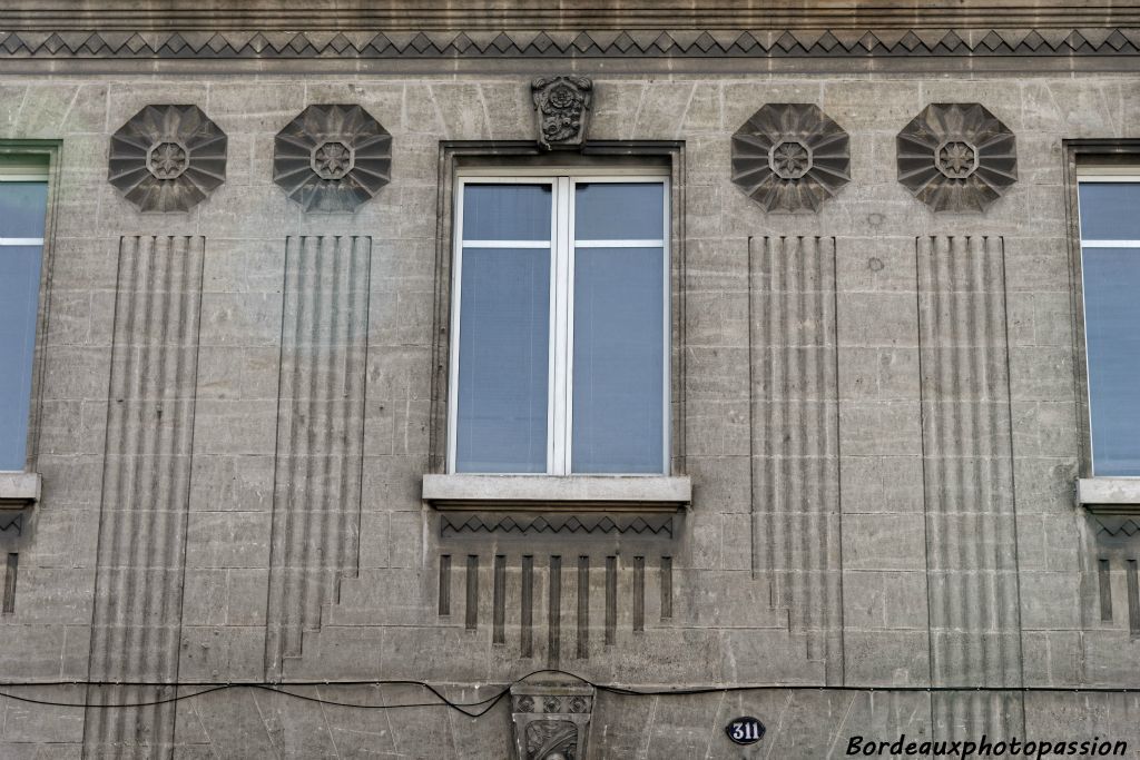 Des rosaces géométiques tombent  des lignes incisées évoquant des chapiteaux sur leur pilastre.