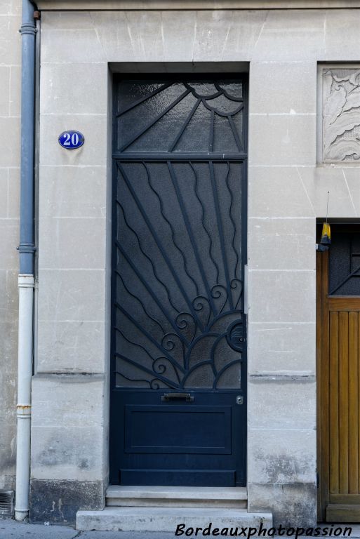 Porte d'entrée en ferronnerie simple et rayonnante.