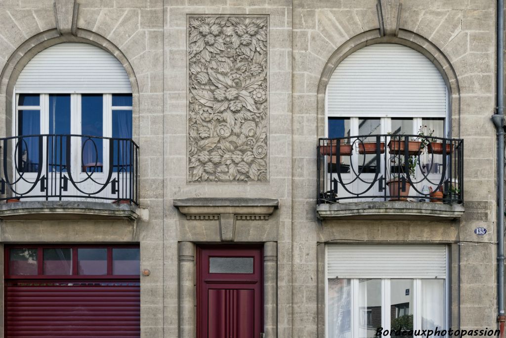 De larges baies avec des balcons cintrés, des garde-corps en ferronerie élégante. La porte d'entrée est encadrée de 2 colonnes adossées...