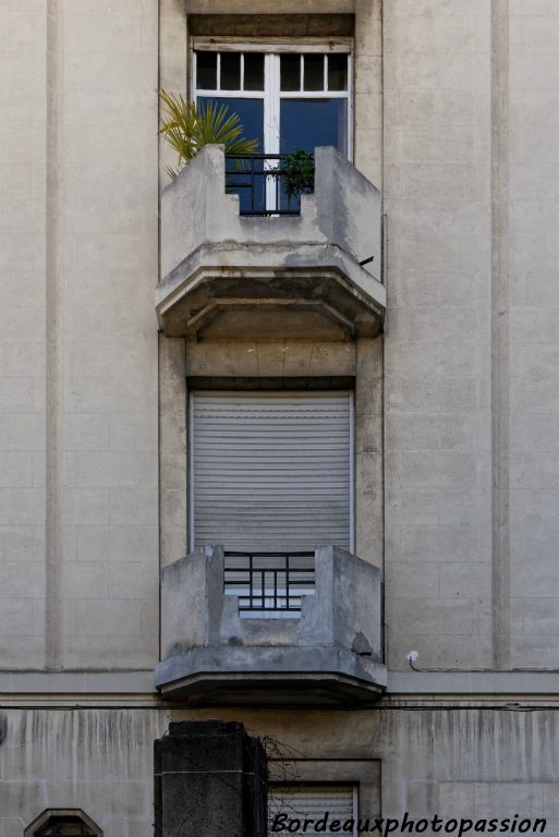 Des balconets abrités et ajourés sont à pans coupés.