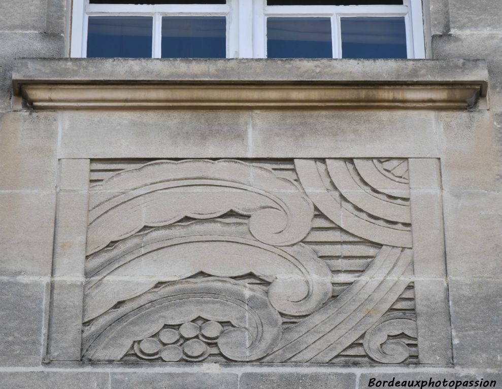 Méplats décoratifs de palmes et feuilles stylisées habillant la façade.