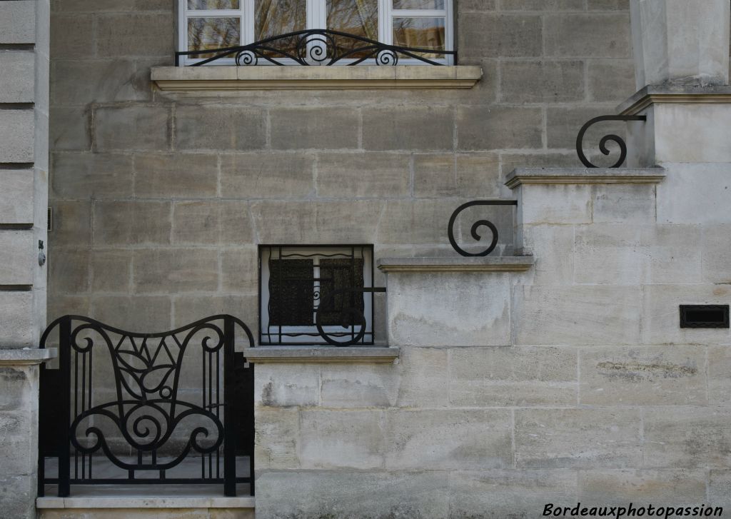 Ferronnerie originale privilégiant la courbe avec spirale. Escalier droit dans l'œuvre.