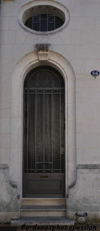 Chambranles concaves et porte de garage ouvragée. Œil de bœuf avec ferronnerie.