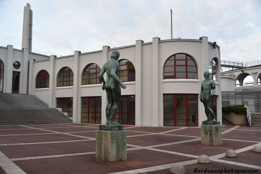 L'architecte a choisi de décorer son entrée-forum par deux statues de nus (comme pour l'entrée côté boulevards avec les vases Buthaud). "Athlète masculin" est d'Auguste Janniot, auteur aussi à Bordeaux du bas-relief en pierre sur la façade de la bourse du travail. "Figure de femme" est de Marcel Damboise.