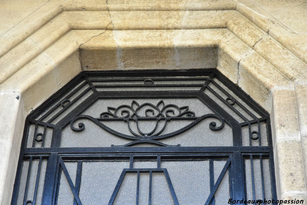 Porte avec ferronnerie vasque et fleurs.