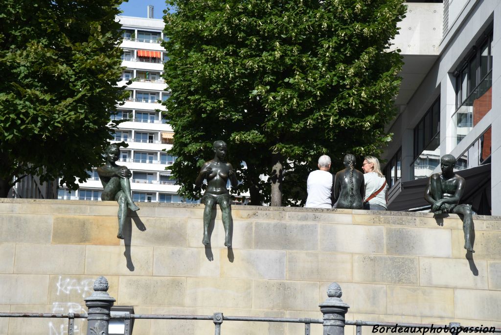 Quatre jeunes filles en bronze posées sur le bord de la Spree.