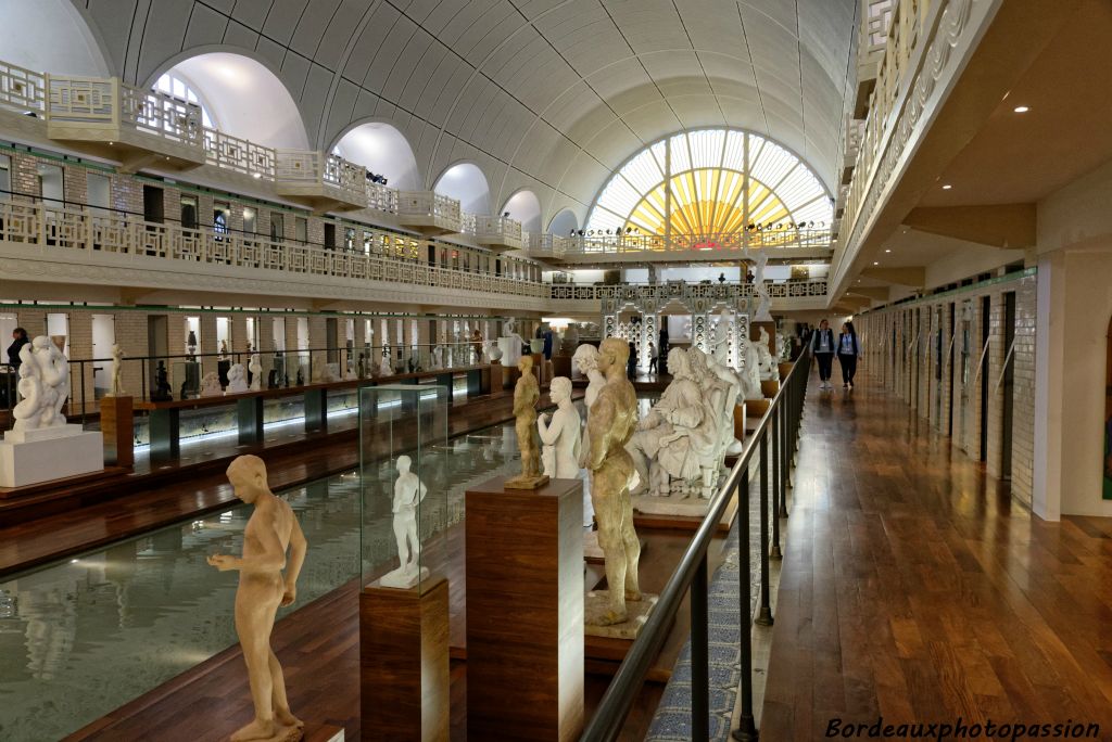 Une galerie surélevée permet d'admirer les statues de dos et leurs reflets dans l'eau du bassin.