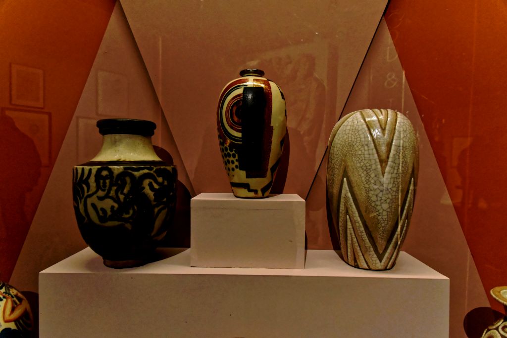 À gauche Vase aux trois nues dansant (1925) au centre : Vase à rehauts d'or sur fond terreux vers 1934. À droite Grand vase à décor géométrique à "peau de serpent" signé "Doris".