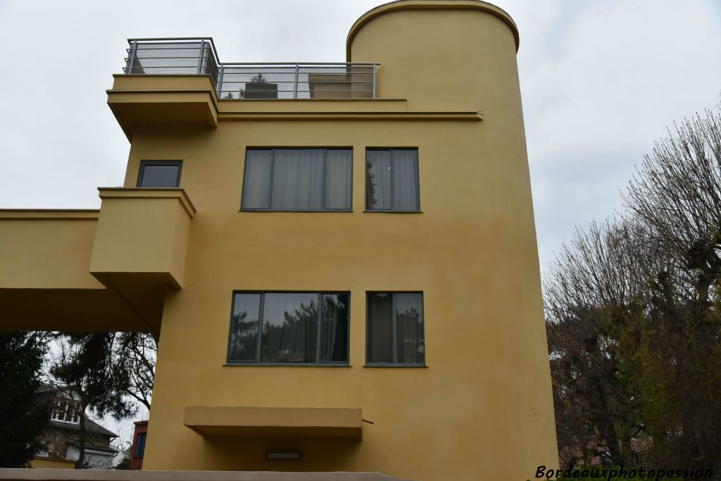 L'entrée est protégée par un auvent. Les pièces d'habitation seront à l'arrière du bâtiment du côté du jardin. La cage d'escalier rappelle la cheminée d'un paquebot avec son bastingage.