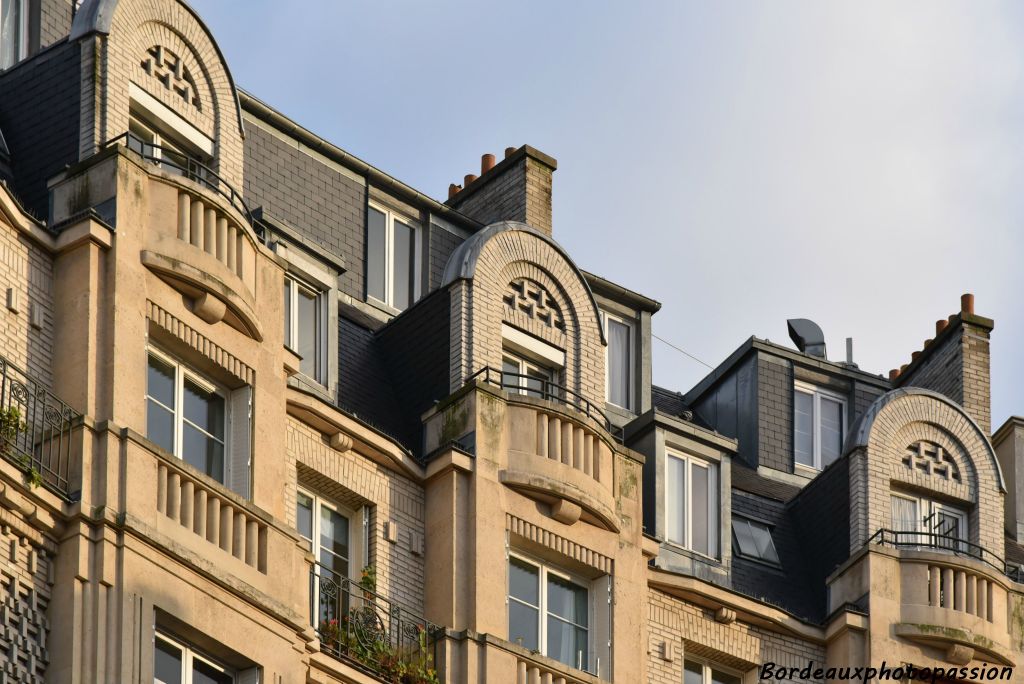 Frontons de briquttes en arc de cercle, balcons avec garde-corps de colonnes.