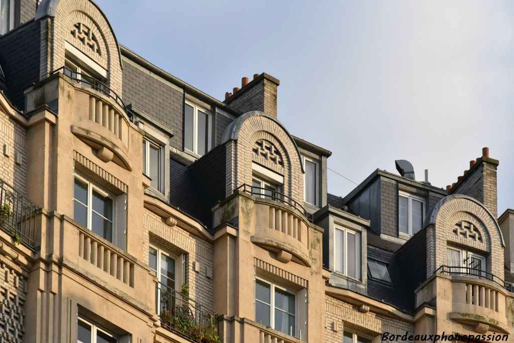 Frontons de briquttes en arc de cercle, balcons avec garde-corps de colonnes.