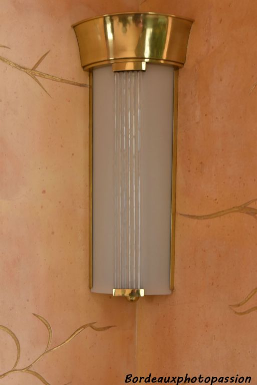 Luminaire dit de cinéma à la mode en 1930 de Genet et Michon. Durant la période Art Déco les lampes ne doivent pas être visibles : toujours dissimulée par un verre. C’est la période ou la lampe linolite (comme un petit tube fluorescent) a été mise sur le marché pour ces appliques.