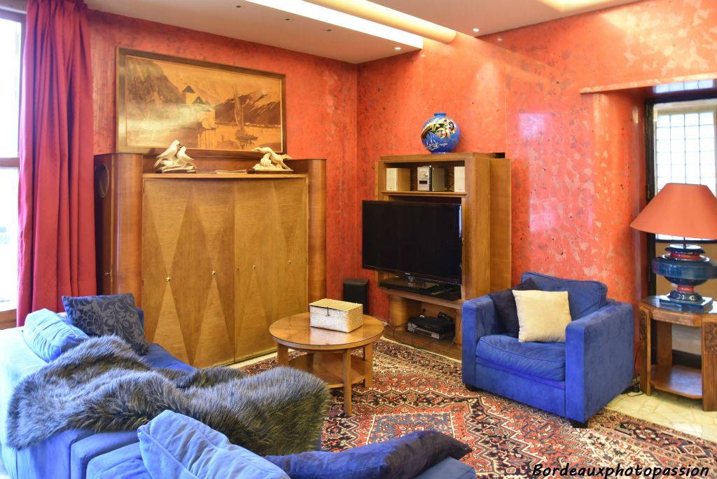Un bout du salon avec meubles de l’époque. Les murs sont recouverts de stuc poli rouge.