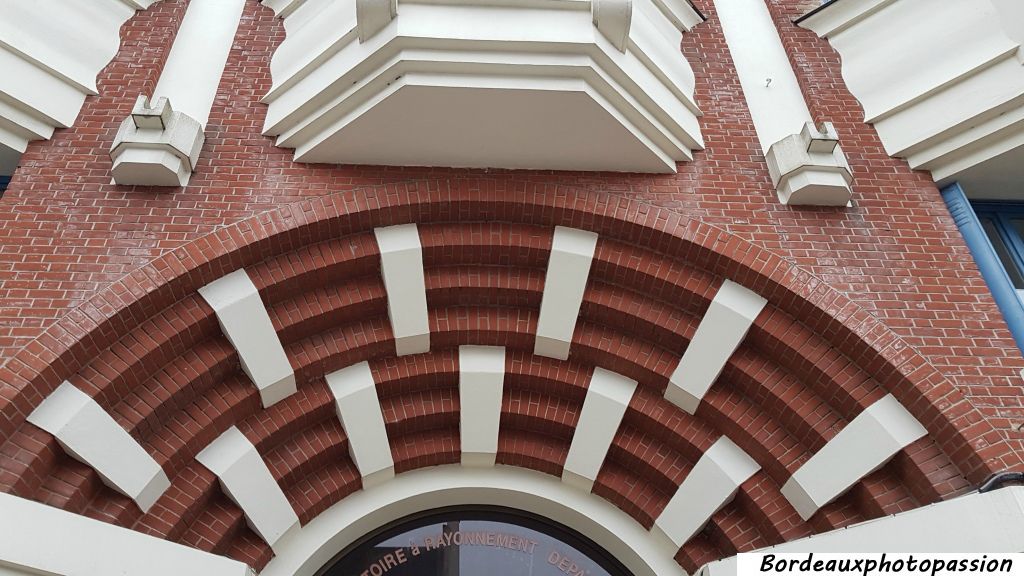 L'arc segmentaire de la porte d'entrée où alternent la brique et le béton.