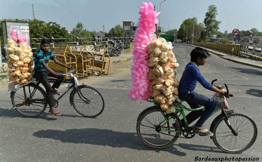 Jeunes, transportant des sachets de barbe à papa sur leur vélo.