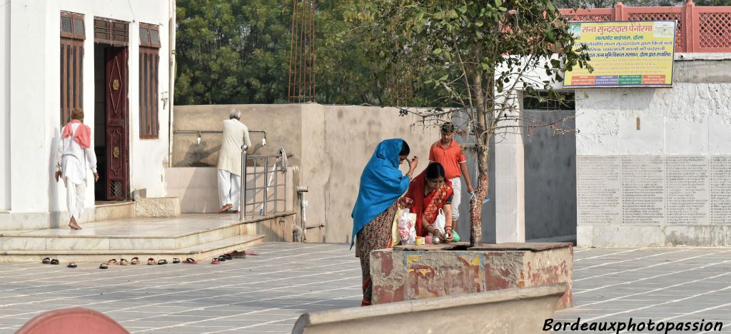 Les femmes préparent leurs offrandes avant d'entrer dans le temple.