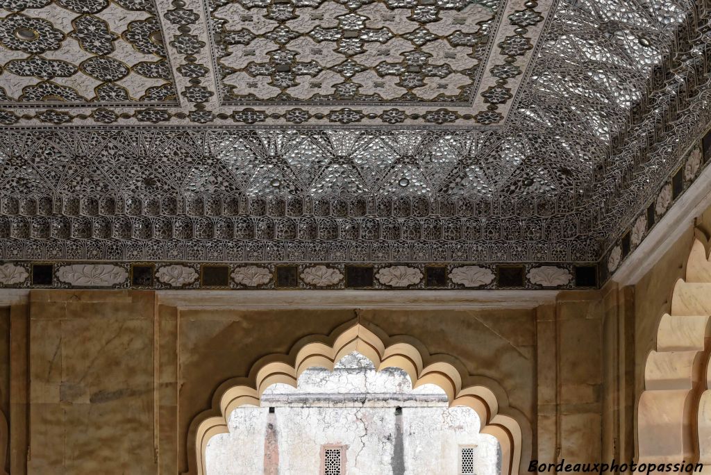 Le plafond est recouvert d'une marqueterie de miroirs et de verres colorés à motif.