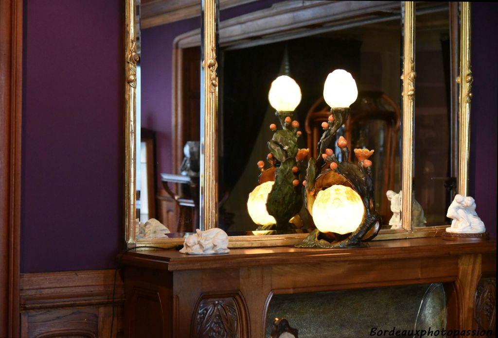 Sur la cheminée, Louis Majorelle et Daum Frères, lampe Figuier de Barbarie, modèle créé en 1903. Bronze patiné, verre soufflé-moulé.
